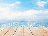 Wooden table top on blue sea and white sand beach